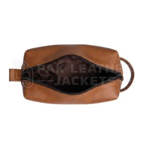 erspective shot of a handmade brown leather organizer bag showing the grain and zipper detail.